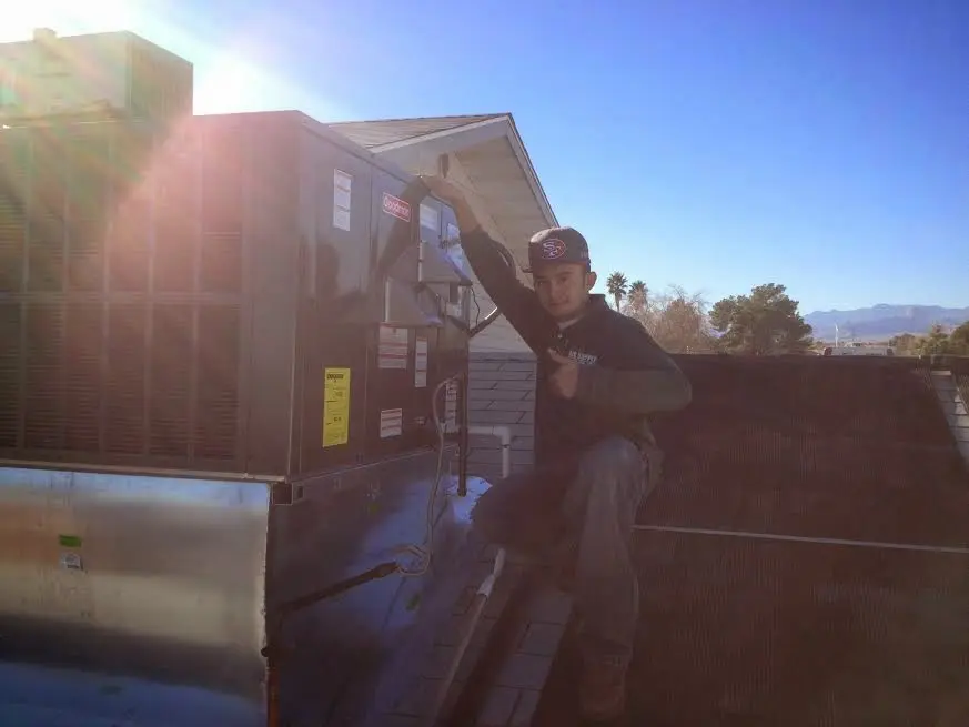 HVAC technician performing Boiler Repair on a rooftop unit in Midway